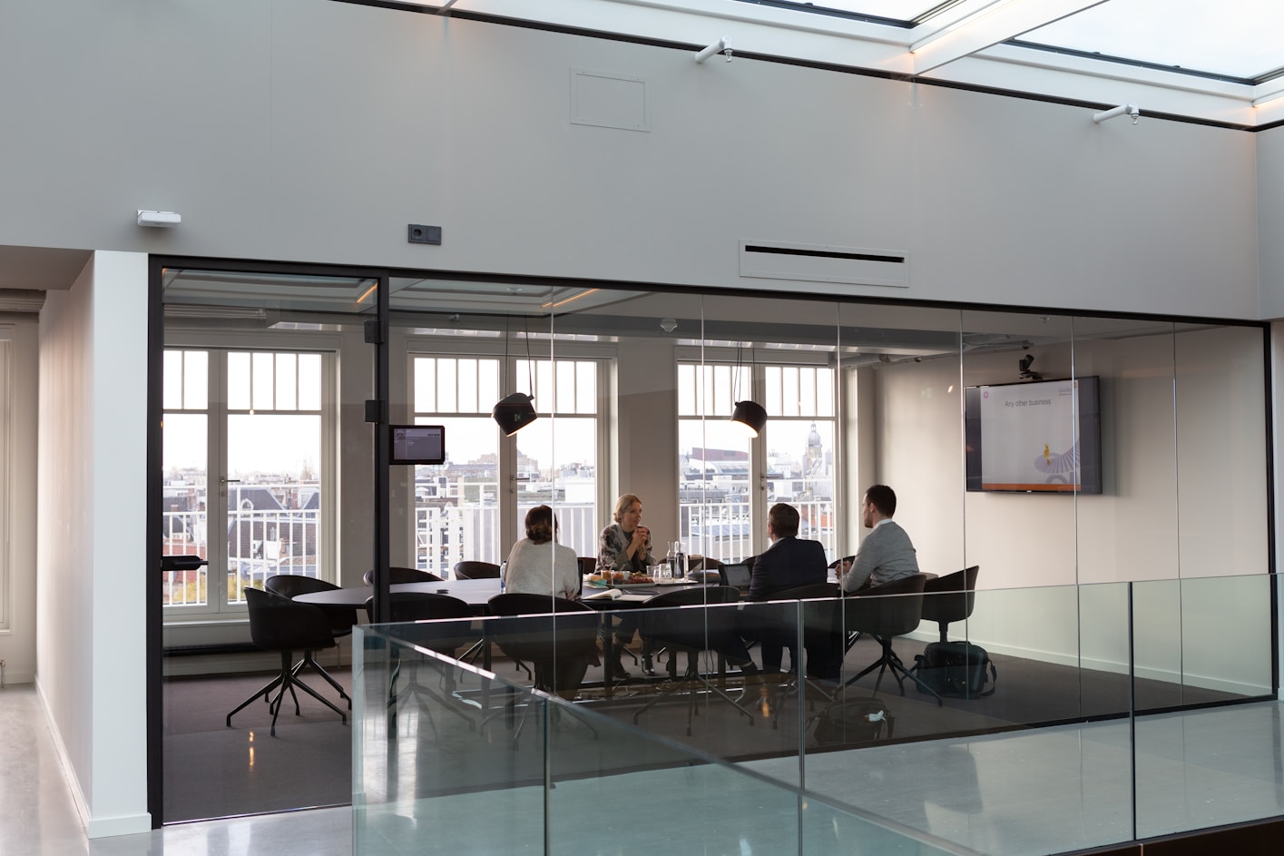 A meeting takes place between 4 colleagues around a large conference table.